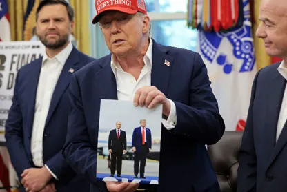 Donald Trump drží fotografiu seba a Vladimíra Putina.